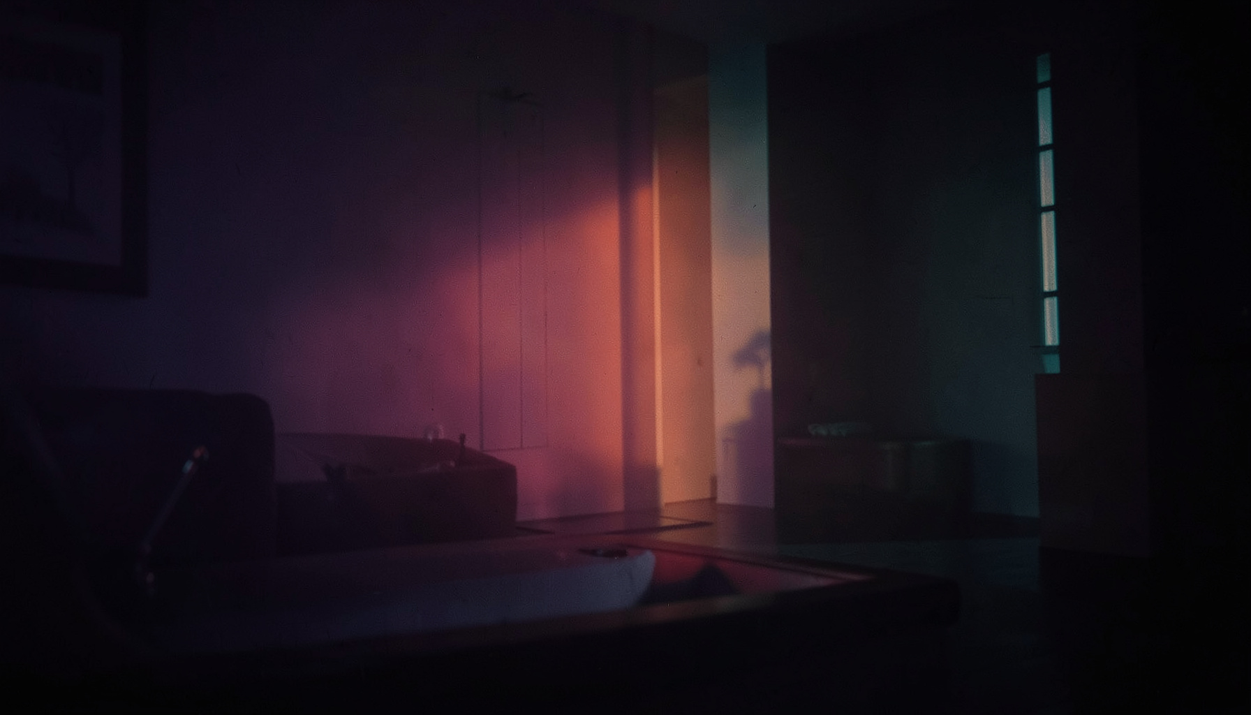 A dark atmospheric photograph with deep purple and teal tones, soft ambient light washing across a moody interior space