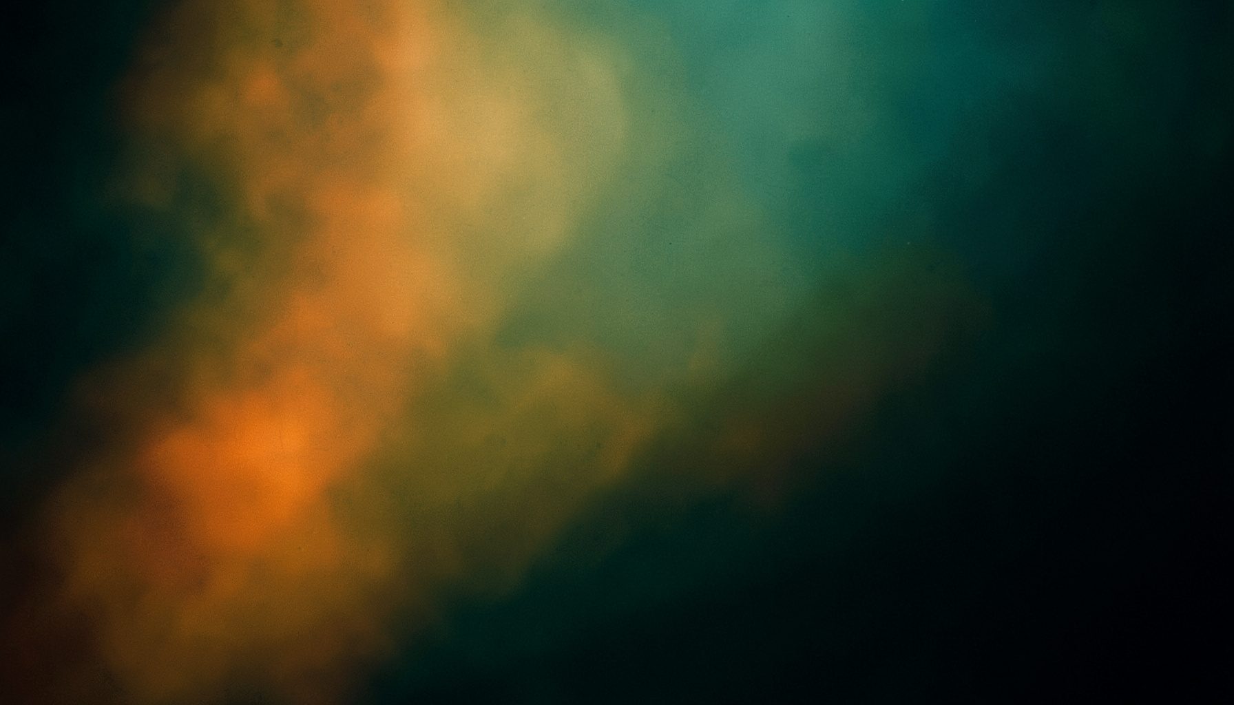 Rich teal and gold tones blending across a dark atmospheric frame with soft focus