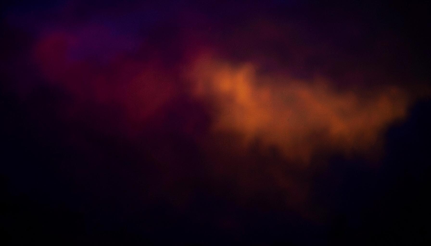 A dark cinematic frame washed in magenta and deep blue light, evoking a quiet late-night atmosphere